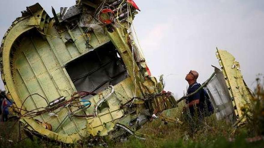 Un investigador, junto a los restos del avión en julio de 2014. // Reuters