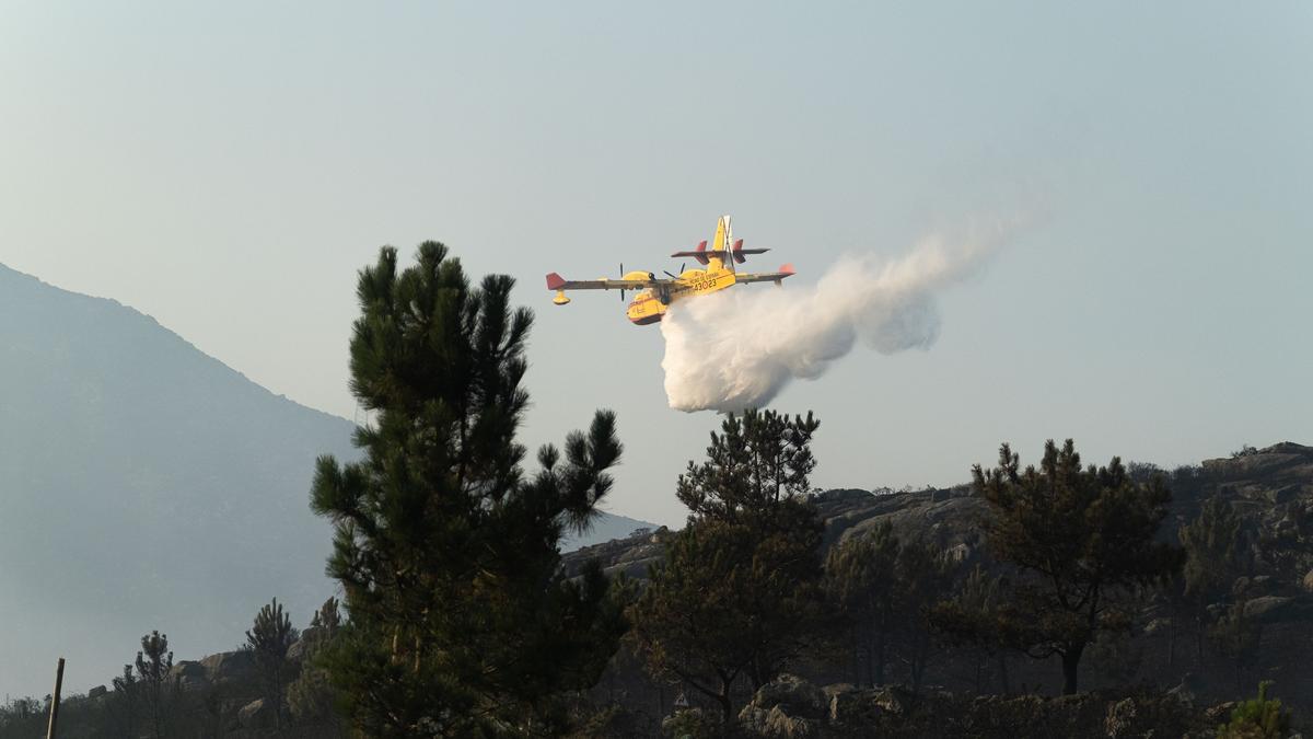 Un avión de extinción de incendios trabaja en el fuego iniciado en Boiro el sábado.