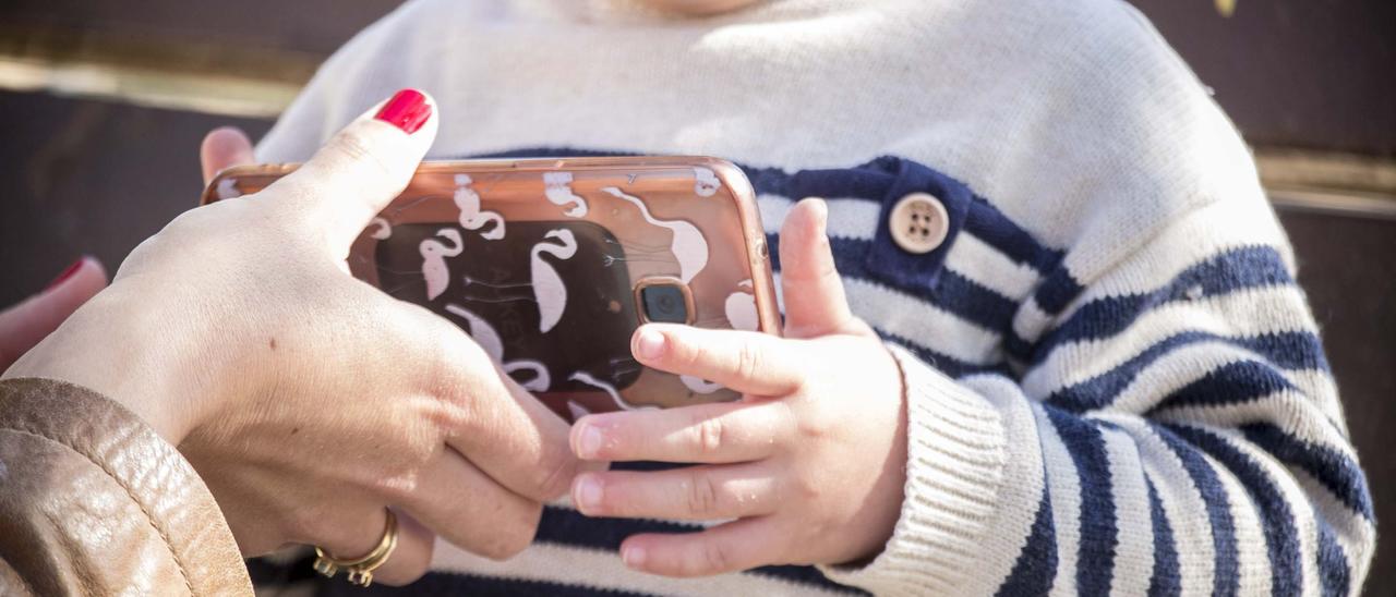 Un niño de dos años con un teléfono inteligente en sus manos