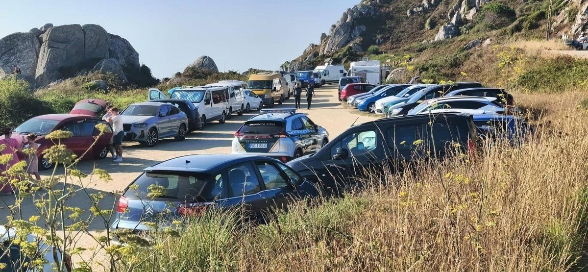 Coches estacionados en Donón, con una patrulla de la Guardia Civil controlando el lugar.