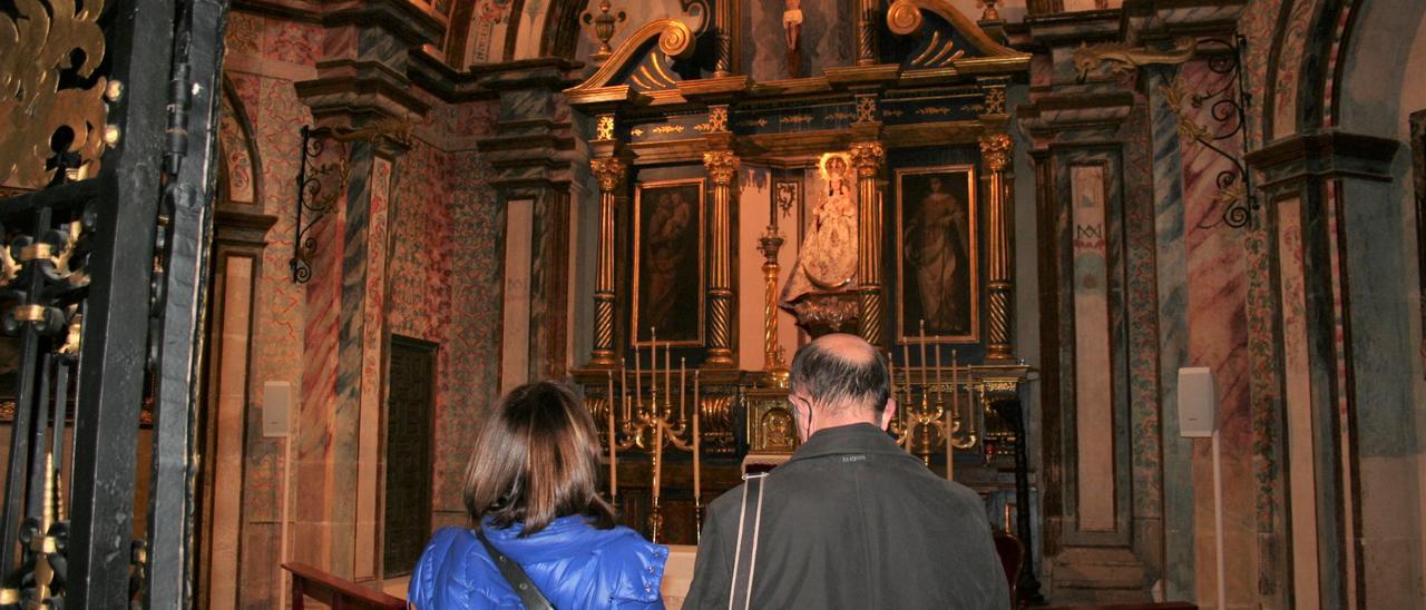 Dos turistas contemplan la Capilla del Alcázar de la antigua colegial.