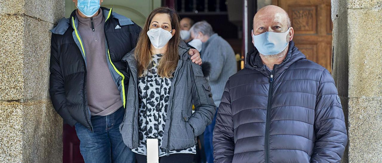 Antonio, su mujer Isabel y Julio, ayer a mediodía, a las puertas de un bar del centro de O Carballiño con café para llevar.   | // CARLOS PETEIRO