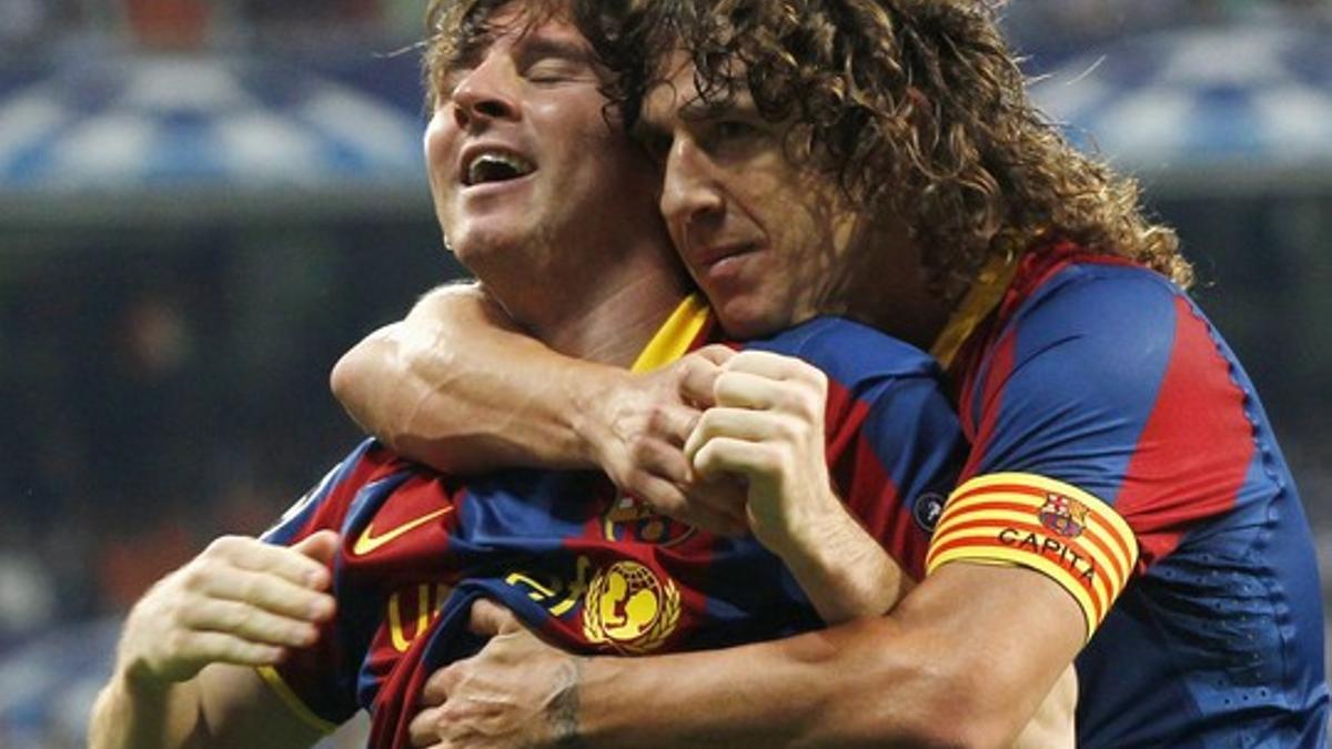 Puyol se abraza a Messi tras uno de los dos goles que el argentino ha marcado al Madrid.