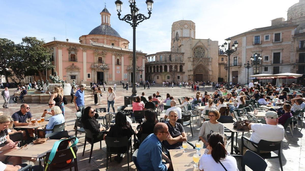 La Plaza de la Virgen de València se llenó ayer de gente en manga corta por las altas temperaturas