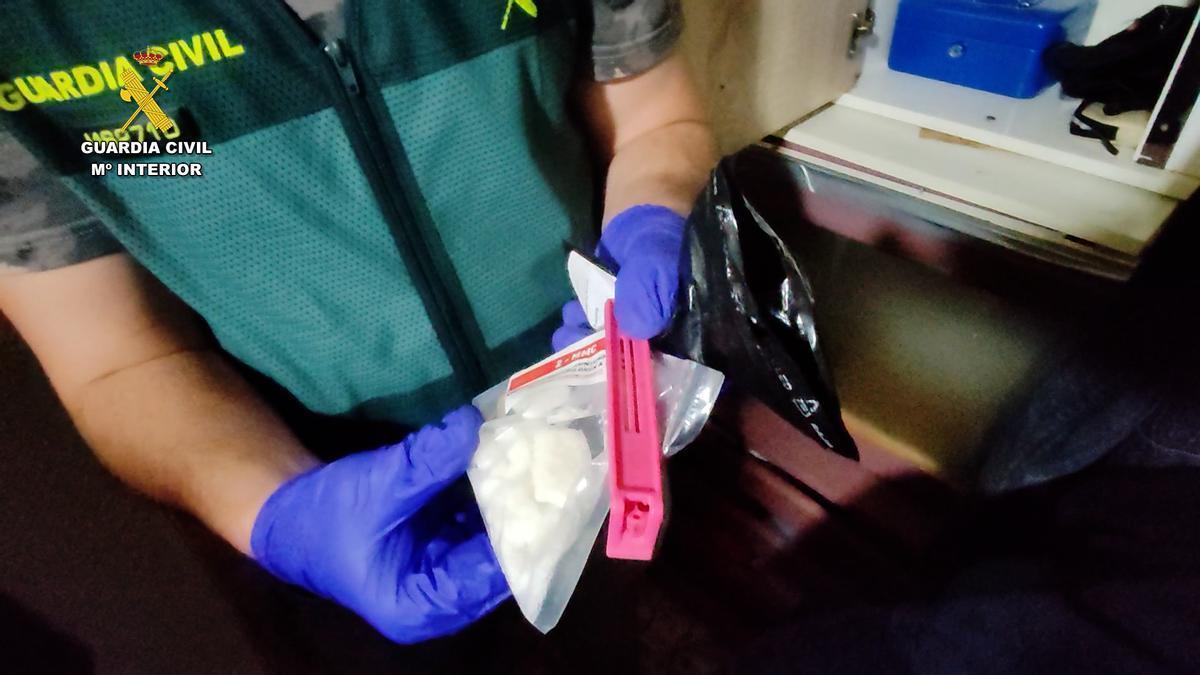 Un guardia civil muestra una bolsa con alfa intervenida en uno de los dos narcopisos desmantelados en julio 2024 en València.