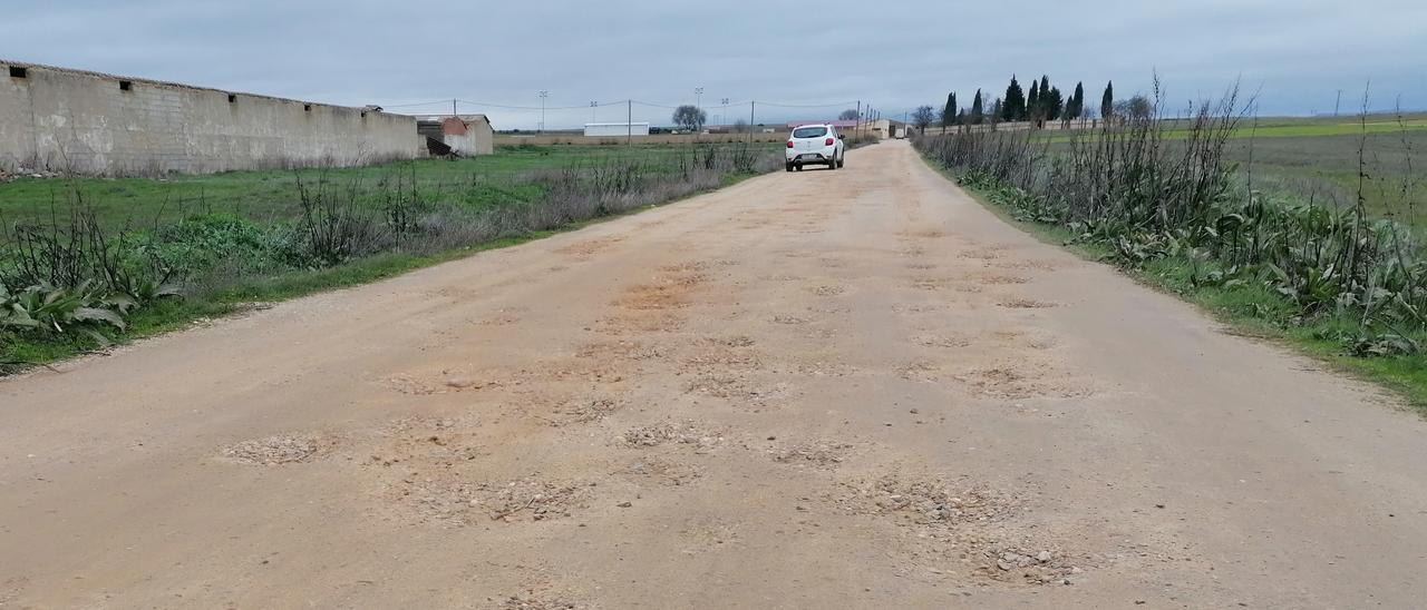 Un vehículo sortea los baches en uno de los accesos al recinto deportivo