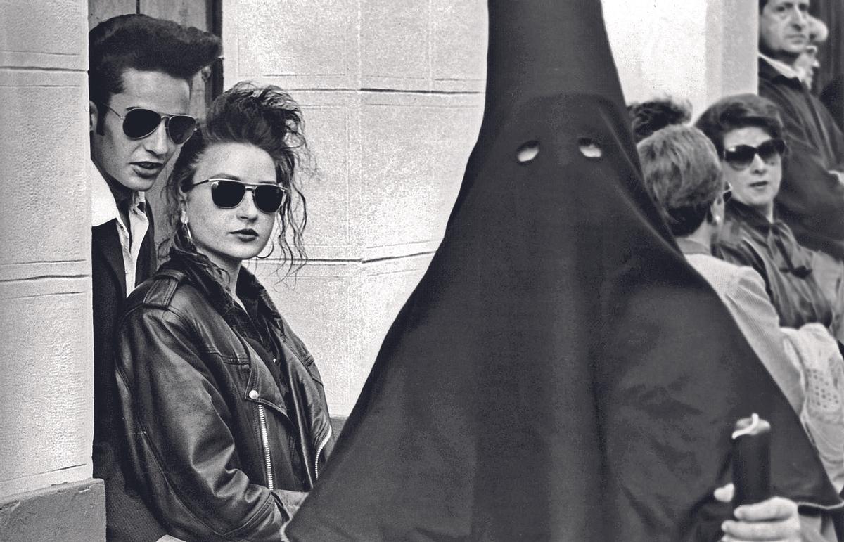 Jovenes cordobeses viendo una estación de penitencia en Córdoba.