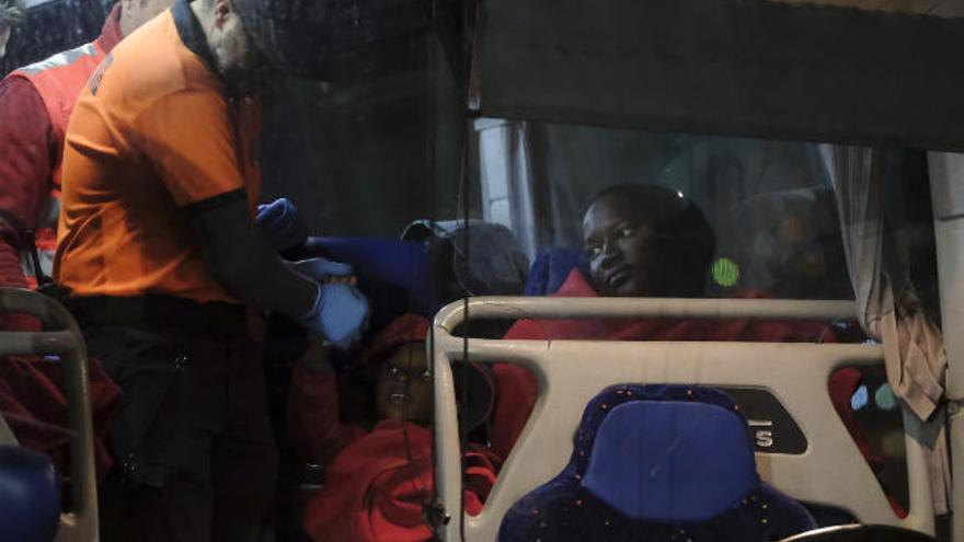 Un miembro de Protección Civil de Mogán da la mano a un niño el pasado jueves en Arguineguín.