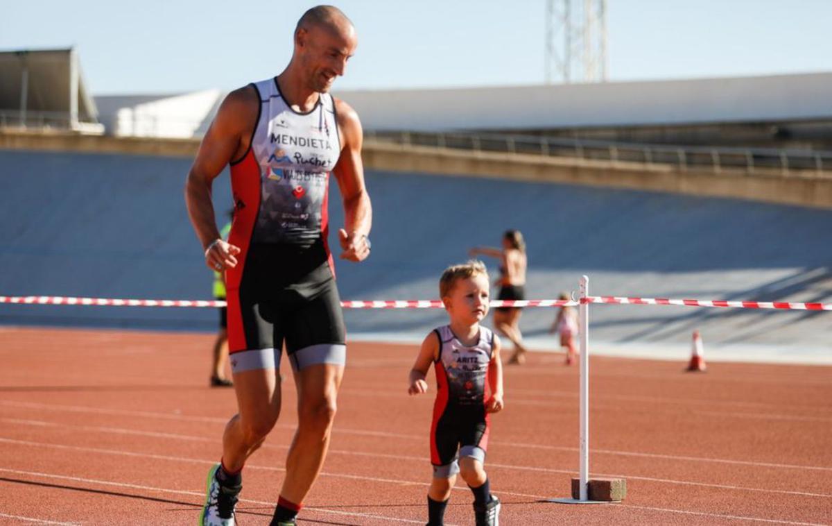 Un niño en la pista de atletismo con su padre. |