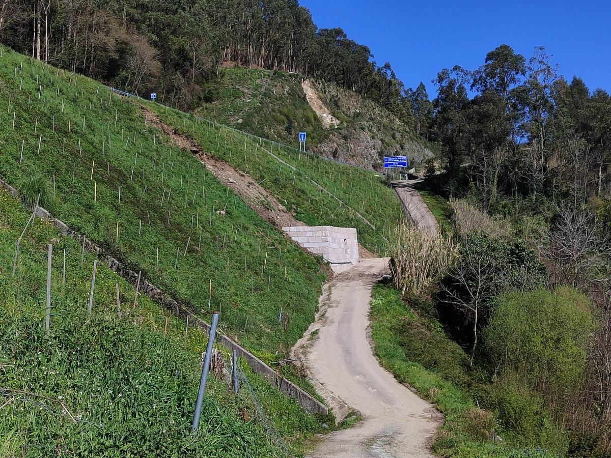 Muro de contención en el talud caído y terraplén al fondo en donde hay desprendimientos.
