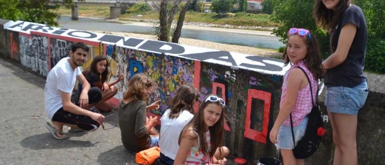 Por la derecha, Carmen Euenco, Olaya Santos, Elena García, Marta Hernando y Covadonga Martínez (ambas de espaldas), Dan Miravalles y Alicia Sierra, ayer, junto al mural del parque de La Llera.