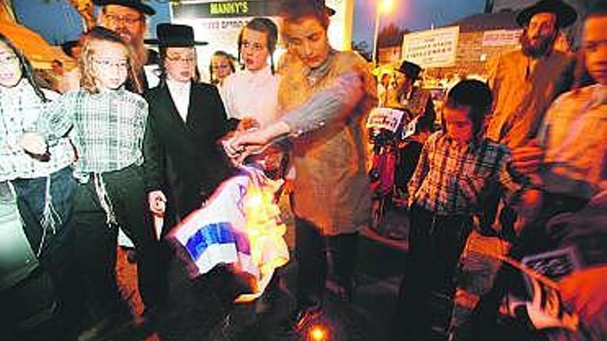 Judíos ultraortodoxos hasídicos, antisionistas, queman una bandera israelí en Jerusalén en protesta contra el Estado judío, que ayer cumplió 62 años.