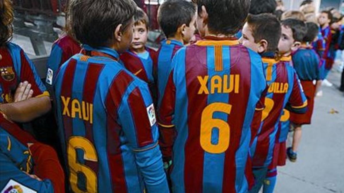 Ídolo 8 Niños con la camiseta de Xavi esperan para salir al campo y fotografiarse con los jugadores.