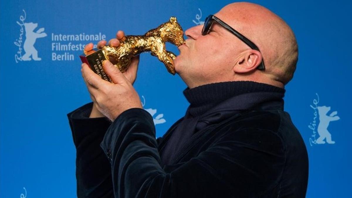 Gianfranco Rosi besa el Oso de Oro tras conseguir el máximo galardón en la Berlinale por su película 'Fuocommare'.