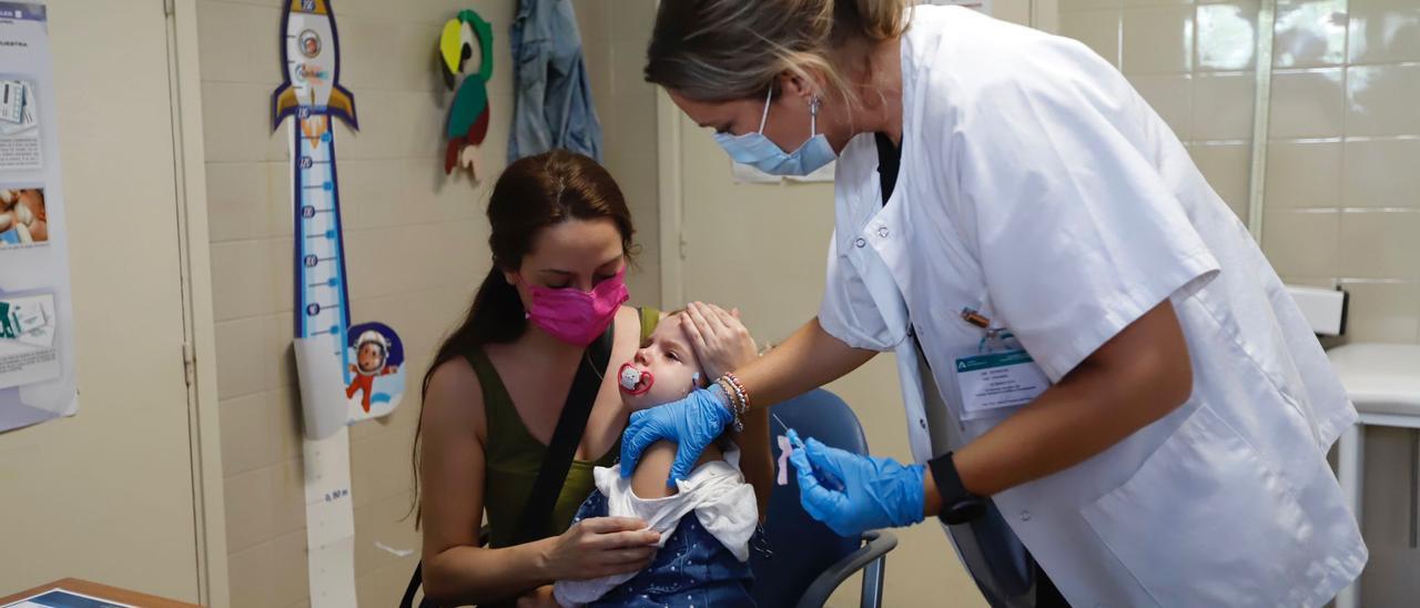 Una niña de dos años se vacuna frente a la gripe en Córdoba.