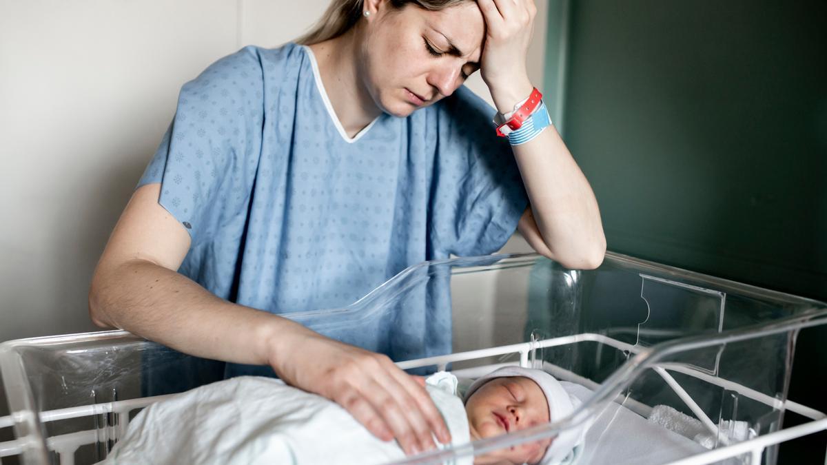Mujer triste con bebé recién nacido