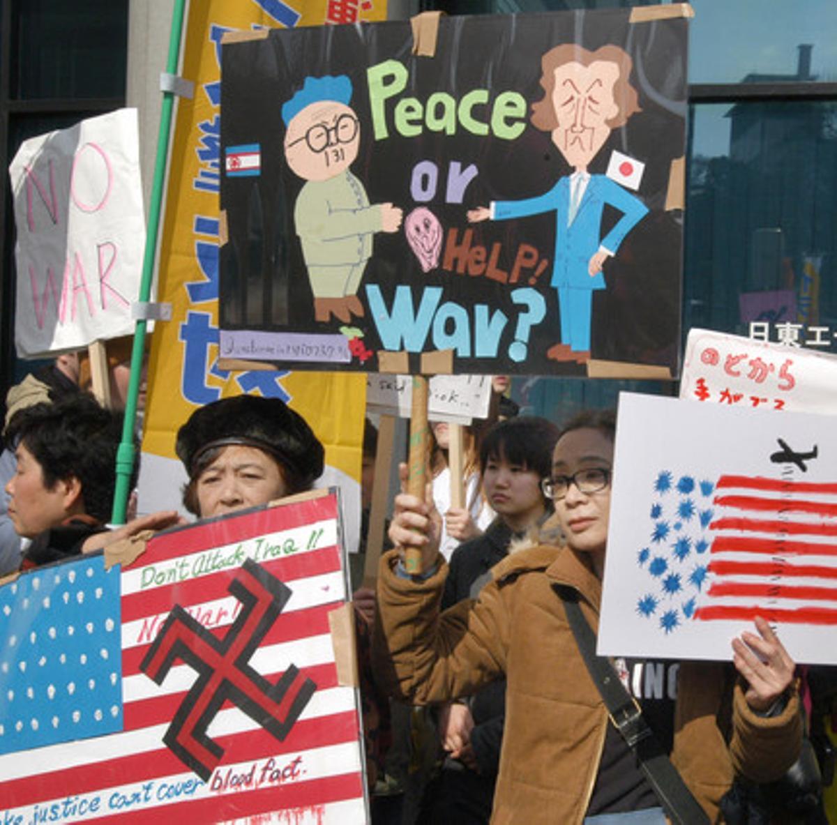 A la convocatoria antibelicista en Tokio respondieron cerca de 25.000 personas, según las cifras de los organizadores. La protesta tuvo lugar delante de la embajada estadounidense. En la foto, un manifestante levanta una pancarta que muestra al primer ministro japonés, Junichiro Koizumi (derecha), y al líder de Corea del Norte, Kim Jong II, al lado de una frase que dice: ’¡Paz o ayuda! ¿Guerra?’. El Gobierno japonés que encabezaba Koizumi no veía con buenos ojos la voluntad de Estados Unidos de atacar militarmente a Irak.