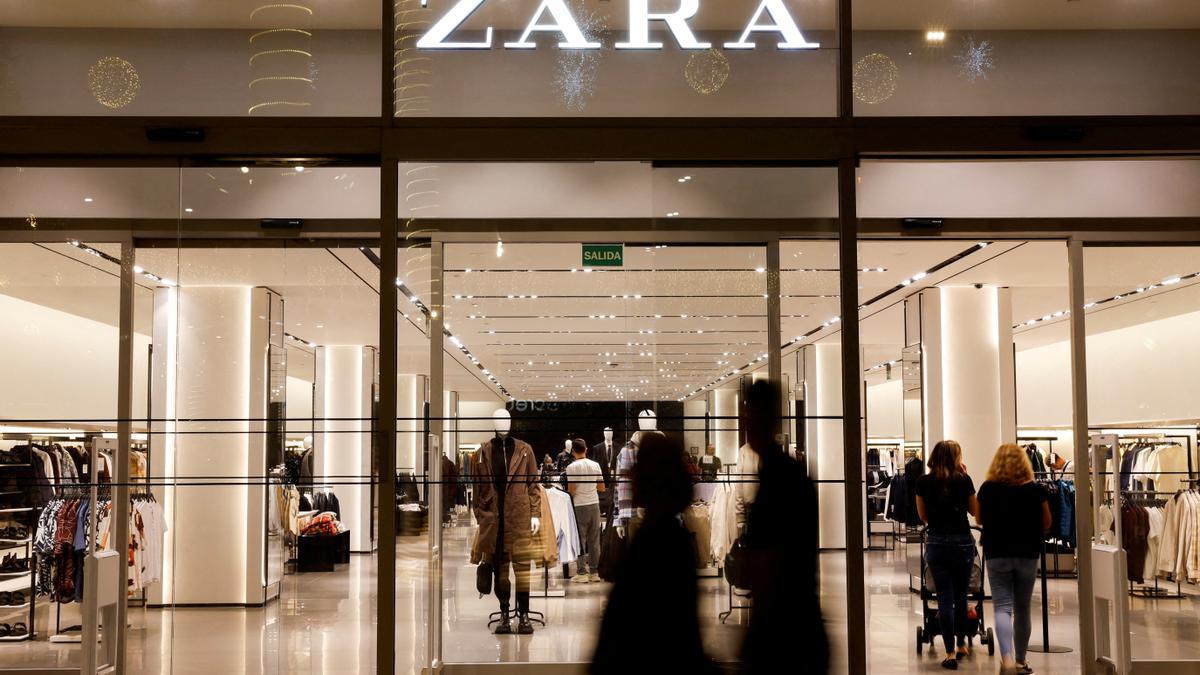 FILE PHOTO: Shoppers walk past a Zara clothes store, part of the Spanish group Inditex