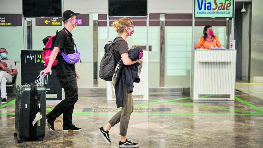 Una pareja de turistas británicos en la terminal de salidas del aeropuerto de Tenerife Sur. | | ANDRÉS GUTIÉRREZ