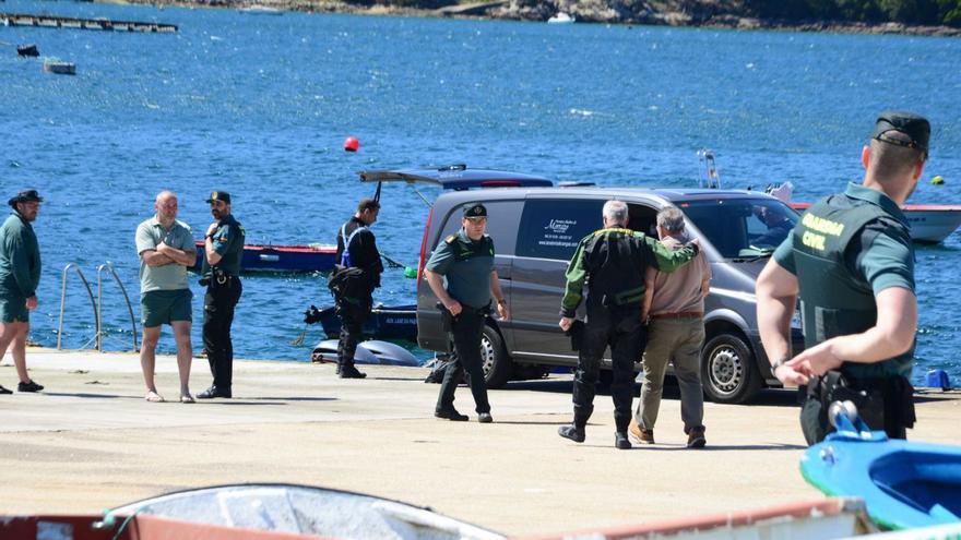 La Guardia Civil en el muelle de Aldán, a donde se trasladó el cadáver del pescador, apoya a un familiar.