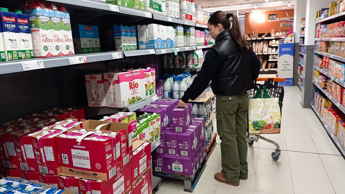 Una clienta cogiendo leche en un supermercado, este enero.