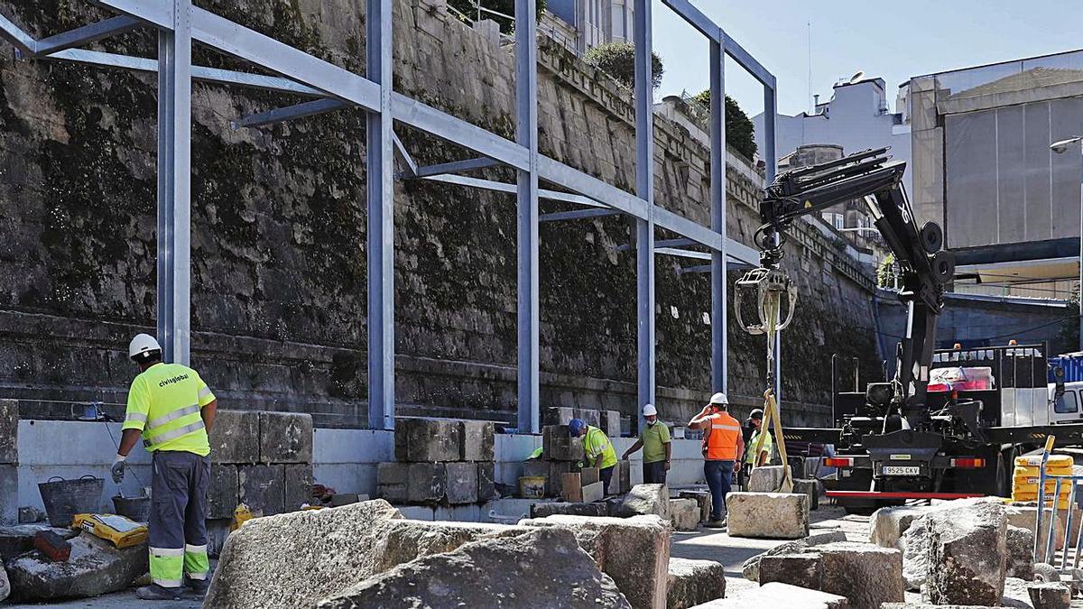 Operarios levantan la estructura y las piedras de la vieja fachada del siglo        XIX en Praza da Estación.  | // P. HERNÁNDEZ