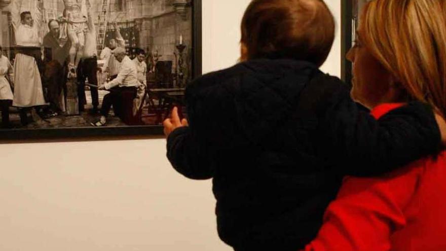 Una mujer observa con un pequeño una de las imágenes.