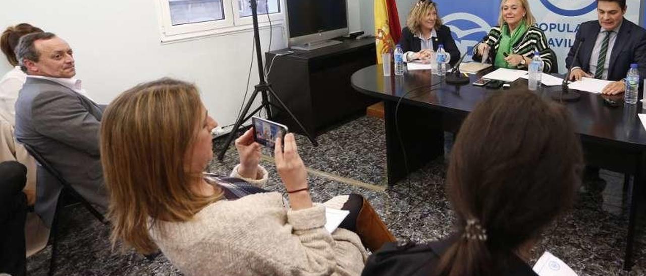 Reyes Fernández Hurlé fotografía a Esther Llamazares, Mercedes Fernández y Pedro de Rueda antes de una reunión en la sede del PP avilesino.