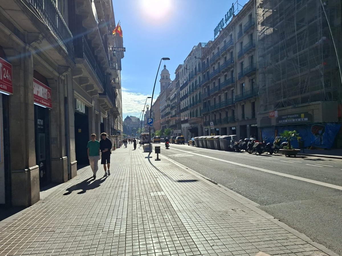 Imagen de la calle de Pelai, con contenedores y motos en uno de sus laterales, esta mañana.