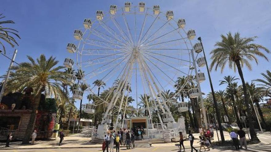 Los visitante suben en la gran noria del Paseo de la Estación, que se ha convertido en uno de los emblemas de la feria andaluza.