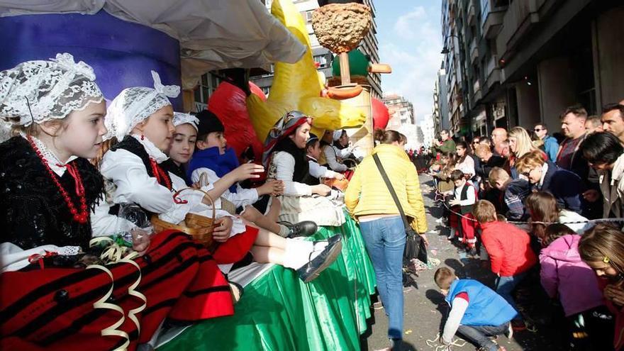 Los pasajeros de una de las carrozas musicales, en la calle José Cueto.