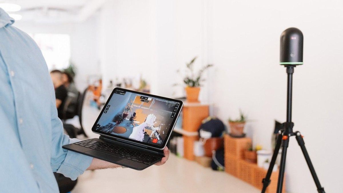 Una tablet muestra la plataforma de visionado de los modelos 3D junto a uno de los aparatos de escaneo láser.