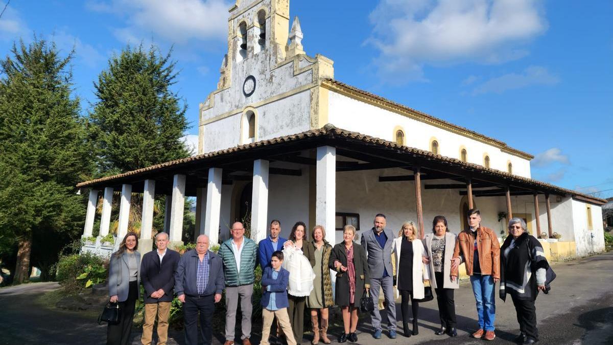 Los padres de Olivia, con la pequeña, en el centro, rodeados de familiares y amigos, ayer, ante la iglesia parroquial de Carda.