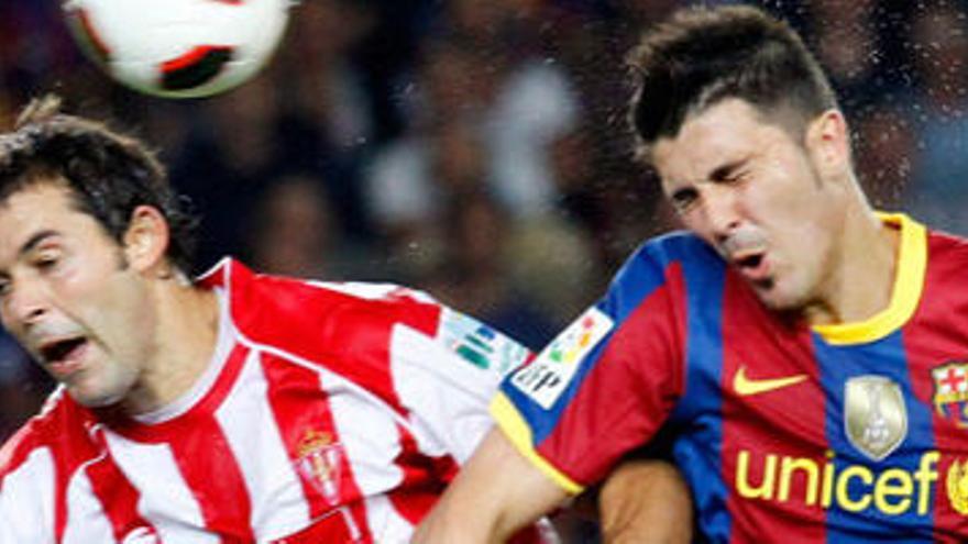 Iván Hernández salta por un balón con Villa.