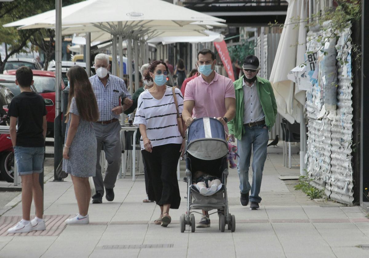 Una pareja paseando ayer con un bebé en la comarca de O Morrazo