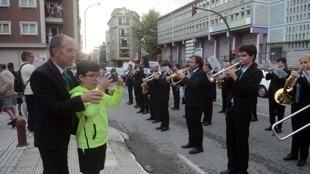 El director de la Banda de Música de Vilagarcía, que no para en estas fiestas, ayuda a un joven a hacer una foto a sus artistas.