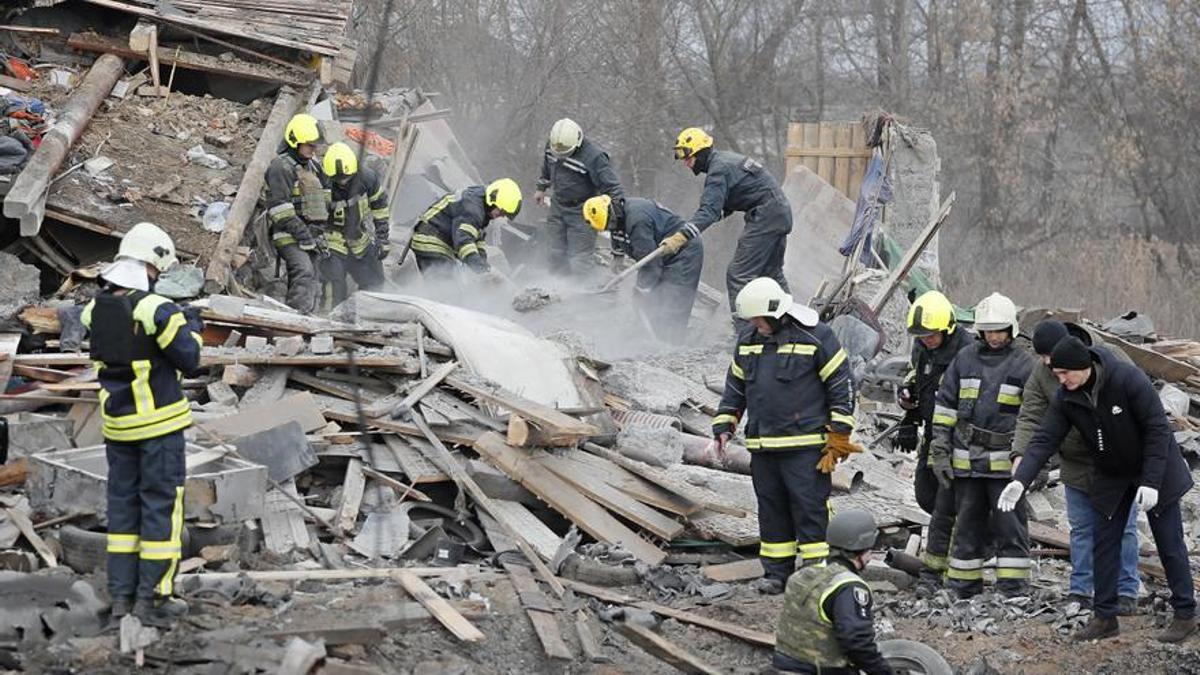 Rescatistas ucranianos en la escena de un edificio residencial destruido tras un ataque con misiles rusos en las afueras de Kiev el 29 de diciembre de 2022.