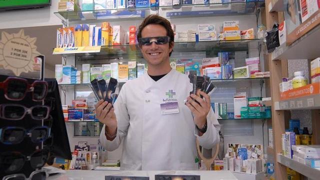 Alberto Lázara posa con varias lentes en su farmacia de Prado. | BERNABÉ/ JAVIER LALÍN