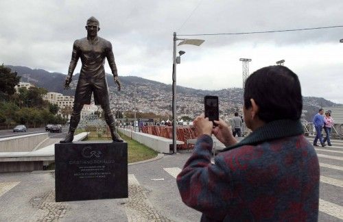 A man takes a photo of a newly-unveiled statue of Portuguese soccer player Cristiano Ronaldo in Funchal