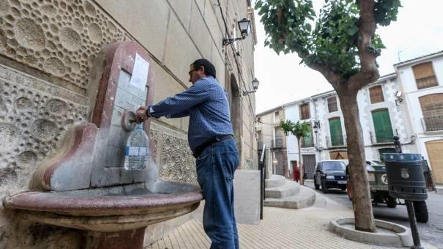 Un vecino de Tárbena llena una garrafa de agua en una fuente de la plaza del pueblo, ayer.