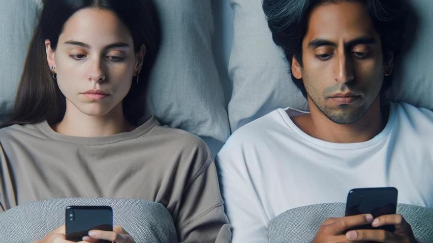 Una pareja junta pero separada mirando sus móviles