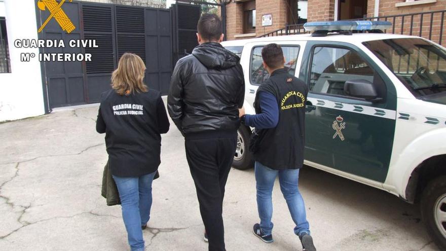 Uno de los detenidos, custodiado por la Guardia Civil