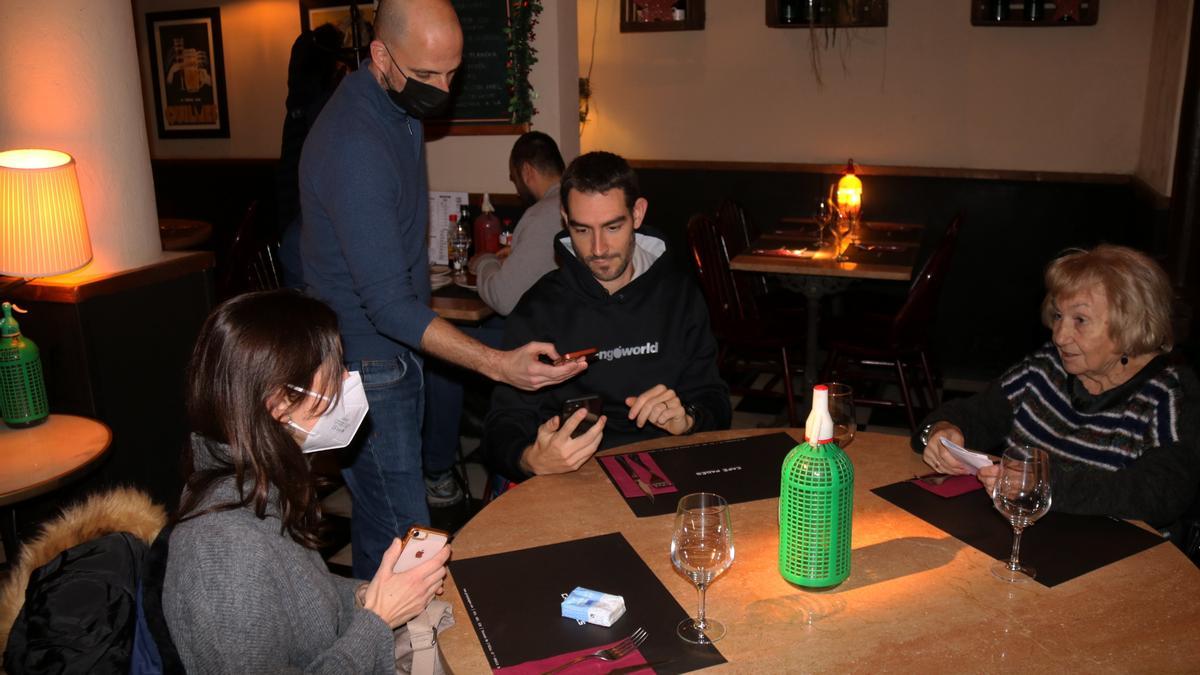 Pla sencer d&#039;un restaurador demanant comprovant el passaport covid en un bar