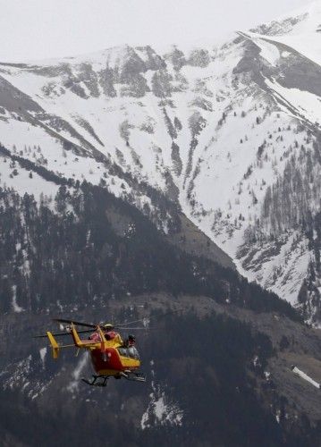 A rescue helicopter from the French Securite Civile flies over the French Alps during a rescue operation next to the crash site of an Airbus A320