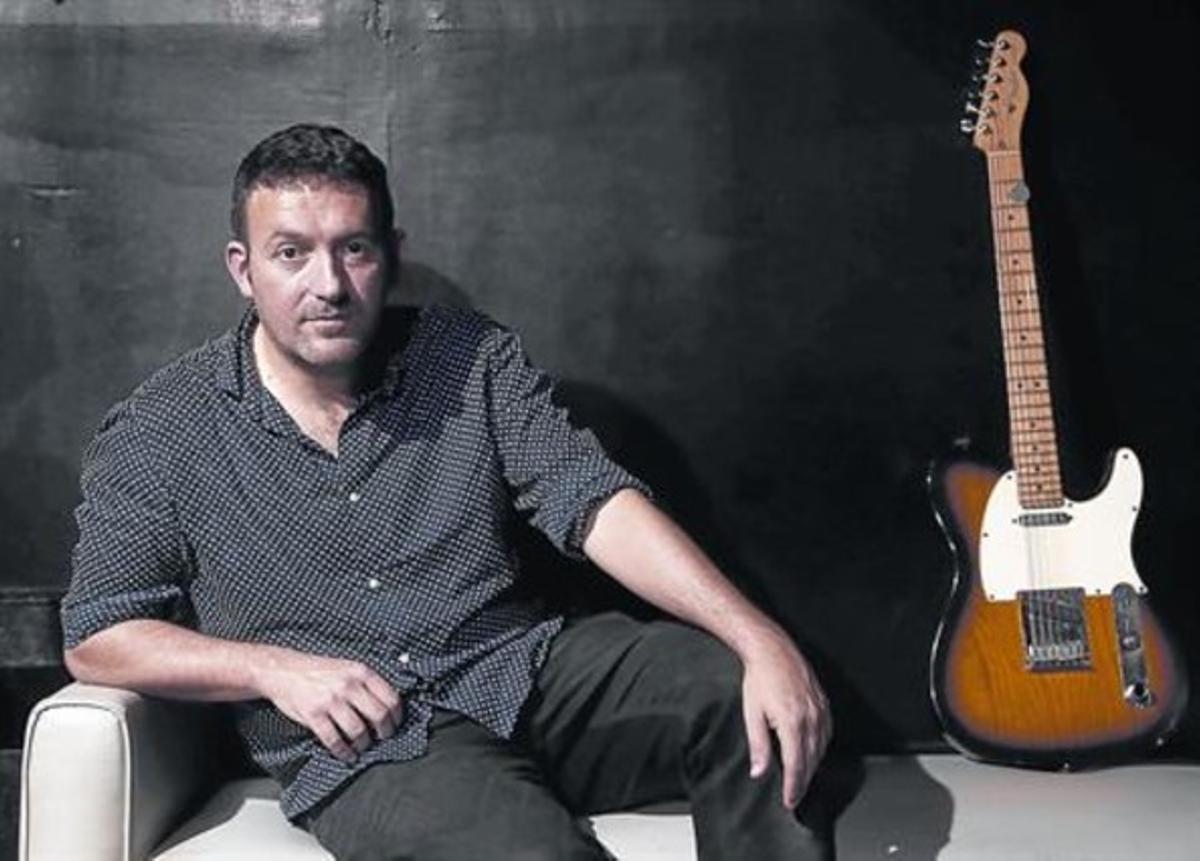 Mikel Santiago, amb una guitarraal club Honky Tonk de Madrid;el rock té un paper en la seva vidai en el seu últim llibre.