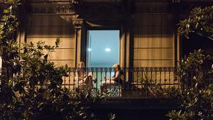 Dos mujeres leen en el balcón de su casa, en Gran de Gràcia.
