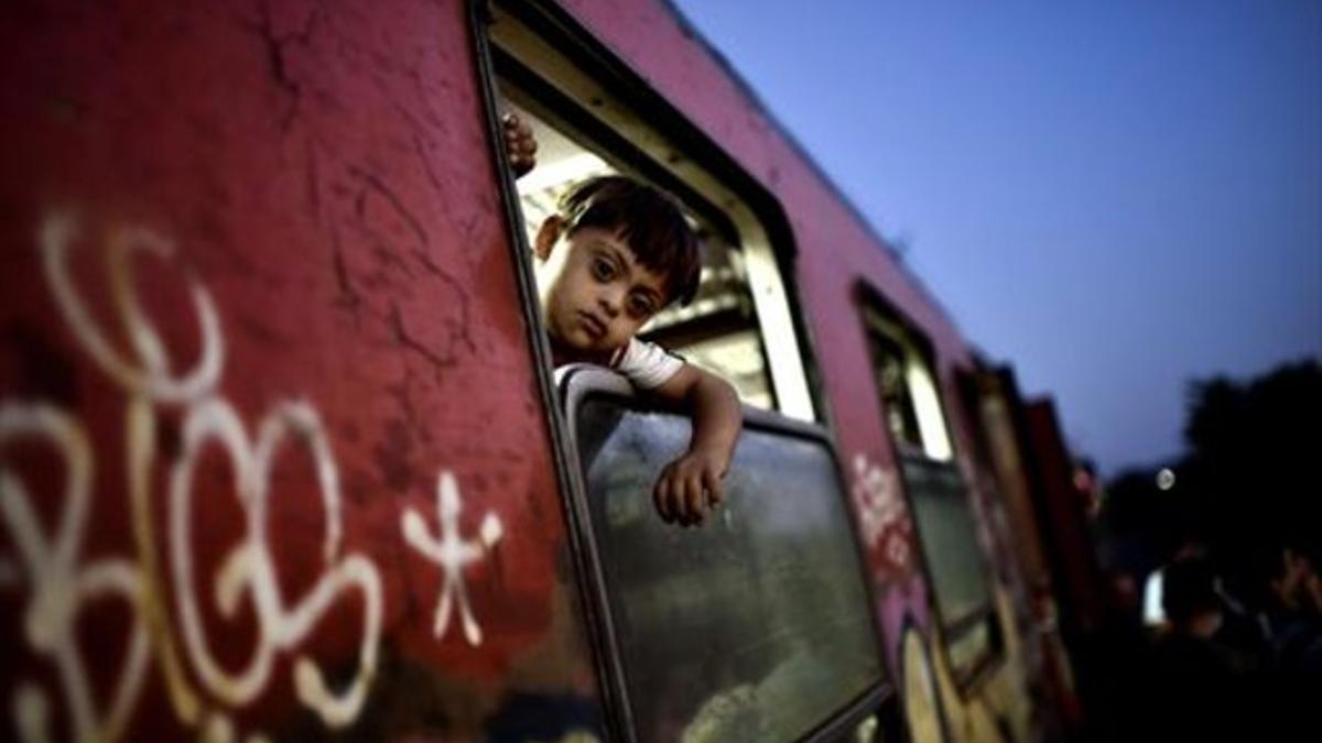 Un niño sirio mira por la ventana de un tren que parte hacia Hungría, ayer.