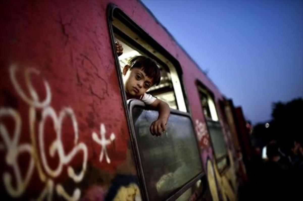 Un nen sirià mira per la finestra d’un tren quesurt cap a Hongria, ahir.