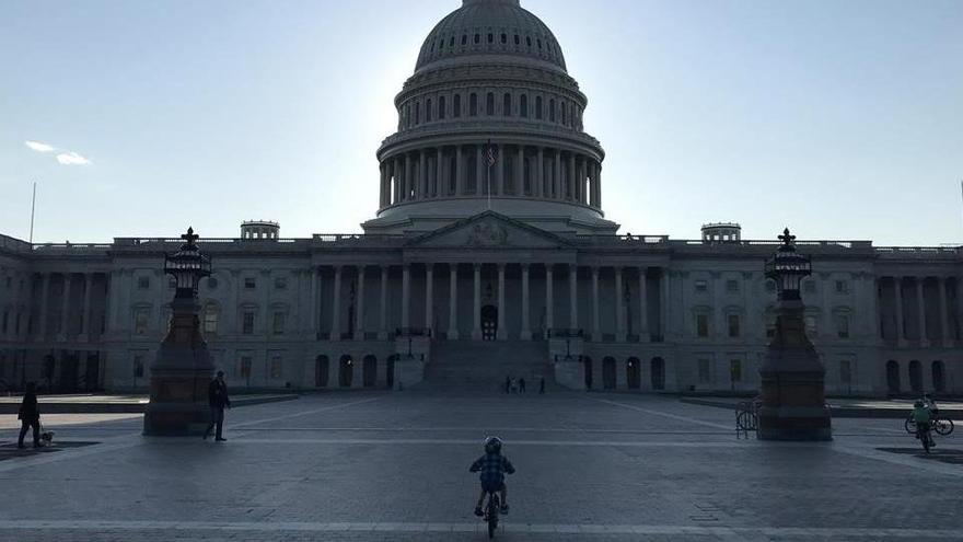 Un niño pedalea frente al edificio del Capitolio, en Washington