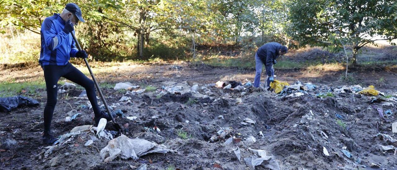 Antón García y Xosé Antón Araúxo retiraban ayer residuos del antiguo vertedero de Couso junto al Bosque da Lingua.